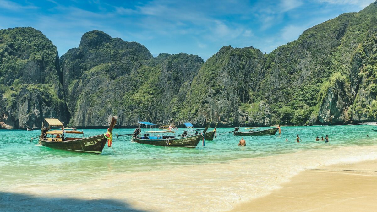 people riding on boat on beach during daytime