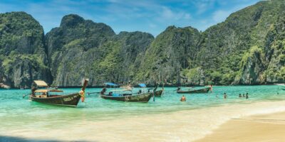 people riding on boat on beach during daytime