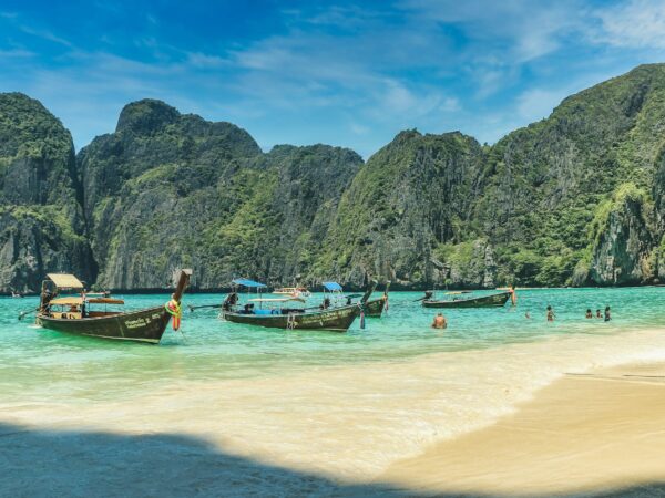 people riding on boat on beach during daytime